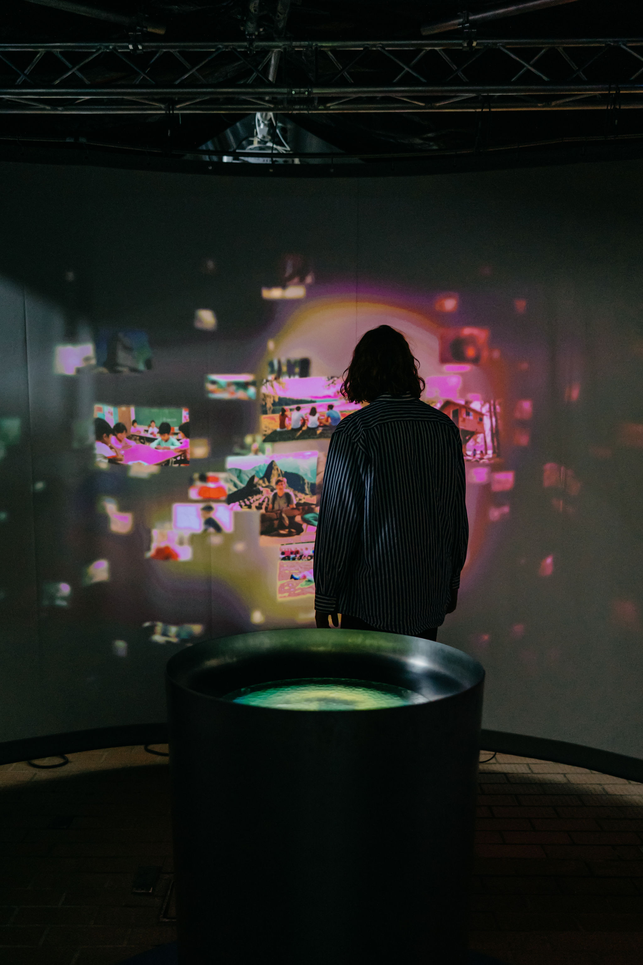 Student observing a wall-sized projection of interactive visual content